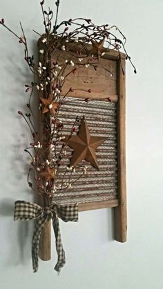 a wooden star hanging on the wall next to a branch with red berries and baby's breath