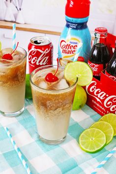 two glasses filled with soda and limes on top of a table