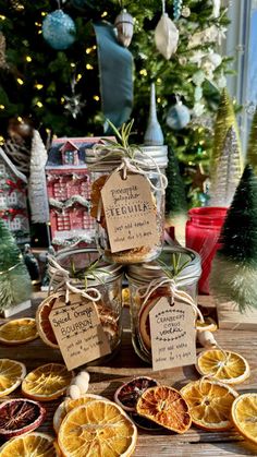 some oranges are sitting on a table with tags in front of them and christmas trees