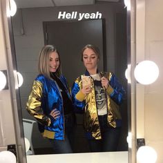 two women standing in front of a mirror