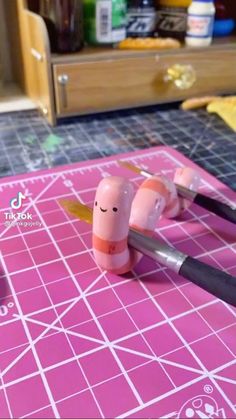 two small toothbrushes sitting on top of a pink cutting board