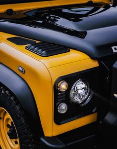 the front end of a yellow and black truck