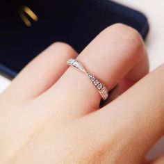 a woman's hand with a diamond ring on her finger next to a cell phone