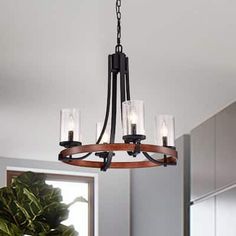 a chandelier hanging from the ceiling in a room with a potted plant