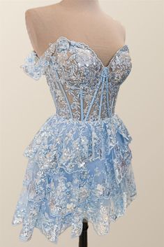 This blue, tulle A-line dress features a semi-sheer bodice with structured boning, off-the-shoulder styling, festive lace appliques, and a lace-up back closure for a chic mini silhouette. Off-shoulder Lace Prom Dress, Party Dress With Lined Bodice And Off-shoulder Design, Homecoming Lace Dress With Lined Bodice, Lace Homecoming Dress With Lined Bodice, Off-shoulder Party Dress With Lined Bodice, Party Off-shoulder Dress With Lined Bodice, Lace Dress With Lined Bodice For Homecoming, Off-shoulder Prom Dress With Lace Bodice, Off-shoulder Lace Bodice Prom Dress