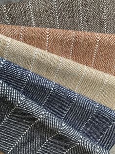 several different colors of tweed fabric on top of each other, including blue and brown