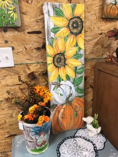 a table topped with vases filled with flowers next to a painting on a wall