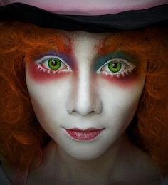 a close up of a person with red hair and green eyes wearing a top hat