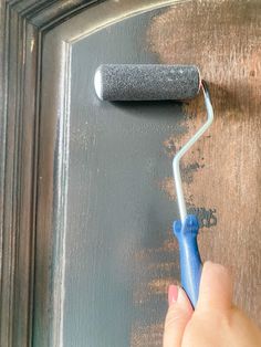 a person using a paint roller on a door