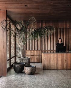 a woman sitting at a counter in front of a palm tree