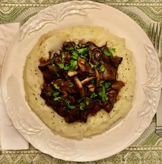 a white plate topped with mashed potatoes and mushrooms