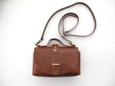 Handmade shoulder leather bag with a classy shape. It can be worn cross-body too and despite its small shape can easily hold your daily essentials. Also, it's a perfect choice for a night out, just remove the shoulder strap and carry it with the featuring top handle. It comes without lining in 6 colors brown, black, goldish black, bordeaux, light gray and ivory. The hardware is available in silver, gold and bronze. WIDTH: 20cm/7.9 inches, LENGTH: 12cm/4.7inches DEPTH: 8cm/3.1inches ADJUSTABLE ST Classic Crossbody Belt Bag For Everyday, Classic Top Handle Belt Bag For Everyday, Everyday Saddle Bag With Top Handle And Phone Bag, Everyday Saddle Bag With Mobile Phone Holder, Cognac Crossbody Shoulder Bag For Gift, Elegant Brown Belt Bag For Everyday Use, Classic Crossbody Shoulder Bag As A Gift, Boho Leather Bags, Fox Bag