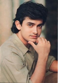 a young man poses for a portrait in an old fashion photo shoot with his hand on his chin