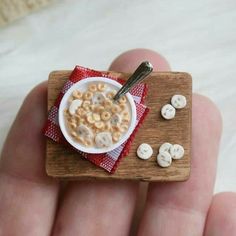 a miniature bowl of cereal on top of a wooden board