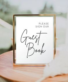 a guest book sitting on top of a wooden table