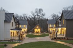 a row of houses lit up at night with lights on the porchs and windows