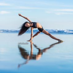 a woman is doing yoga on the beach