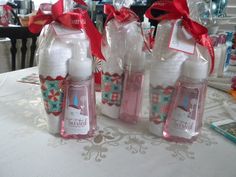 three bottles are wrapped in clear plastic and tied with red ribbon on a tablecloth