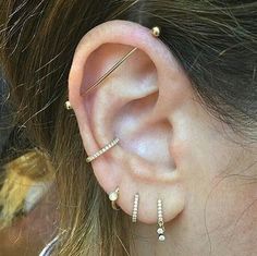 a close up of a person's ear with three different types of piercings