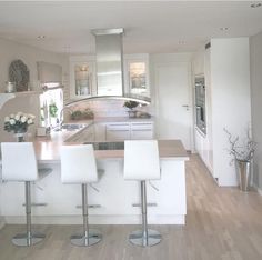 a kitchen with white cabinets and bar stools