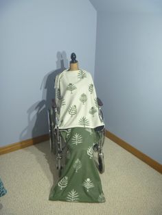 a green and white blanket sitting on top of a chair next to a blue wall