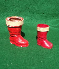 two red and white boots sitting on top of green carpet