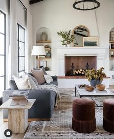 a living room filled with furniture and a fire place in the middle of a room