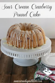 a bundt cake with icing sitting on top of a white cake platter