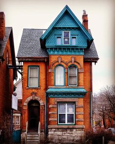 an old red brick house with blue trim