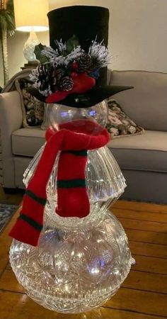 a glass snowman sitting on top of a table