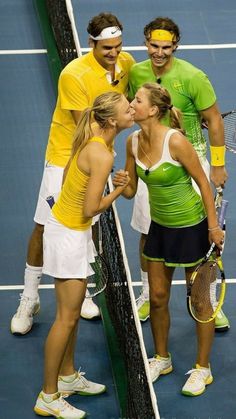 two tennis players giving each other a kiss on the court while three others look on