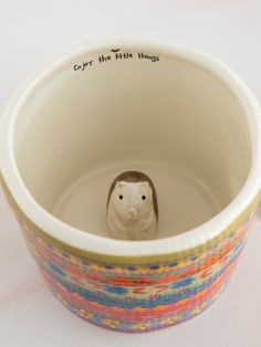 a small ceramic animal in a bowl with writing on it