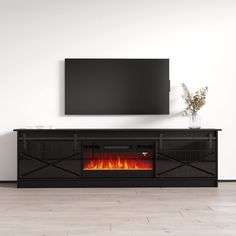 an entertainment center with a television mounted on the wall and a fire place in front of it