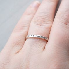 Skinny sterling silver ring that measures 2mm wide stamped with I am Worthy. Ring can come in sizes 4, 5, 6, 7, 8, 9, and 10. *Due to the process of hand stamping in each letter, the ring can stretch to be up to 1/2 size larger. Not sure of your ring size? Head over to this free printable to find your size. https://www.jewelry-secrets.com/Blog/wp-content/uploads/2015/05/Ring-Size-Chart1.pdf All Simpli Stamped jewelry comes ready to gift, packaged in a charming kraft box, tied with a coordinating Meaningful Hypoallergenic Jewelry For Promise Ring, Hypoallergenic Meaningful Jewelry, Meaningful Stamped Jewelry For Promise, Meaningful Hypoallergenic Jewelry For Promise, Meaningful Hypoallergenic Promise Jewelry, Inspirational Promise Jewelry, Hypoallergenic Meaningful Jewelry For Promises, Inspirational Hypoallergenic Everyday Jewelry, Inspirational Everyday Hypoallergenic Jewelry