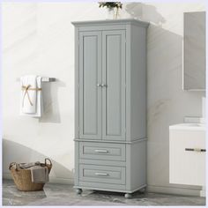 a bathroom with a gray cabinet next to a white sink and towel dispenser