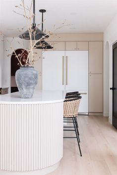 a large vase sitting on top of a kitchen counter next to a bar with stools