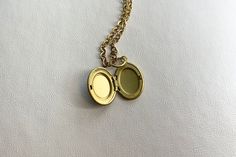 This sweet, small, OVAL antique brass locket has a smooth Labradorite cabochon set on the front.  It hangs on a 16" gold stainless steel chain necklace.  The locket is approximately 11x16mm.  The cabochon is 6x8mm.  Arrives in an eco-friendly jewelry box, ready for gifting. MORE lockets in my shop! FREE SHIPPING! THANK YOU FOR VISITING MY SHOP! Antique Gold Brass Necklace For Keepsake, Nickel-free Brass Charm Necklace With Round Pendant, Dainty Brass Locket Charm Necklace, Handmade Antique Gold Brass Locket Necklace, Gold Brass Dainty Locket Necklace, Antique Gold Brass Locket Necklace, Gold Brass Oval Pendant Charm Necklace, Gold Dainty Brass Locket Necklace, Gold Oval Pendant Brass Charm Necklace