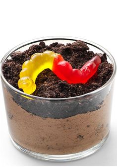 a small glass bowl filled with dirt and a candy worm