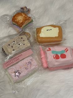 there are four different items in plastic bags on the bed together, including toast and cheese cake