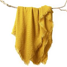 a yellow blanket hanging from a tree branch