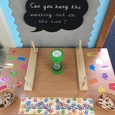 a wooden table topped with lots of crafting supplies next to a chalkboard that says can you hang the missing out on the line?