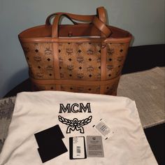 This A Beautiful Never Used Brown And Black Mcm Tote Bag. I Am Moving And Would Like To Sell This Bag Fast. If You Are Serious And Would Love It For Yourself Or To Give As A Gift, Then This Is The Bag For You. Serious Inquiries Only Please... All Sales Are Final, And There Are No Refunds Once Purchased. Designer Medium Shopping Bag, Luxury Medium Bags For Errands, Luxury Medium Bag For Errands, Brown Monogram Canvas Bag With Top Carry Handle, High-end Brown Coated Canvas Bag, Brown Monogram Canvas Bag With Large Capacity, Tan Monogram Canvas Bag For Shopping, Tan Monogram Canvas Shopping Bag, Luxury Medium Shoulder Bag With Removable Pouch