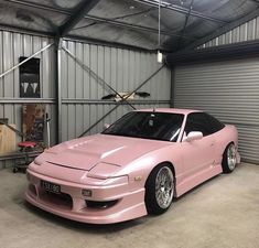 a pink sports car parked in a garage