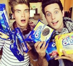 two young men holding up snacks in their hands