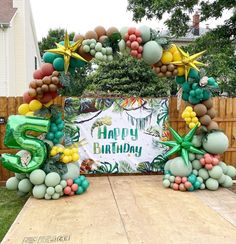 an outdoor birthday party with balloons and decorations