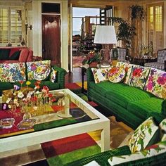 a living room filled with green couches and colorful pillows on top of it's covers