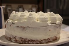 a cake with white frosting sitting on top of a plate