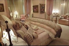 a large bed sitting in the middle of a bedroom next to two couches and lamps