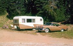 an old car is parked next to a camper