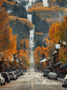 cars parked on the side of a road in front of a mountain with trees and snow